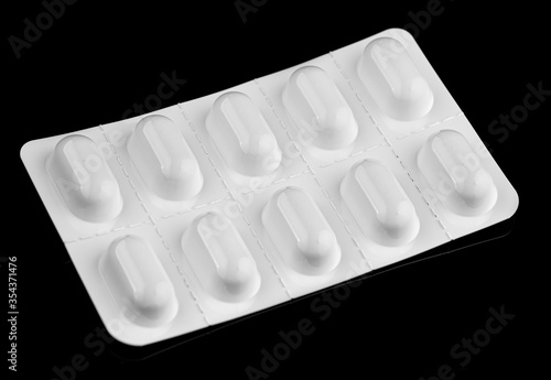 Obraz na plátně Pills in a white blister black background