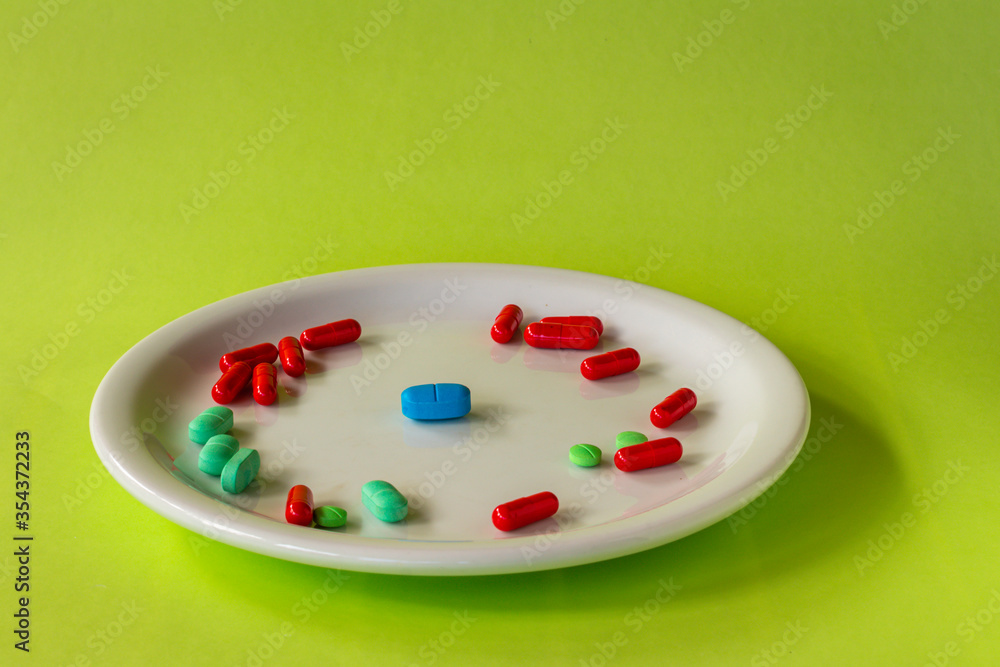 Colored pills on a white plate. Concept of social distancing. Colored pills on a white plate. Concept of social distancing.