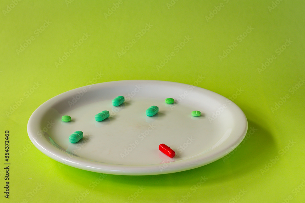 Colored pills on a white plate. Concept of social distancing. Colored pills on a white plate. Concept of social distancing.
