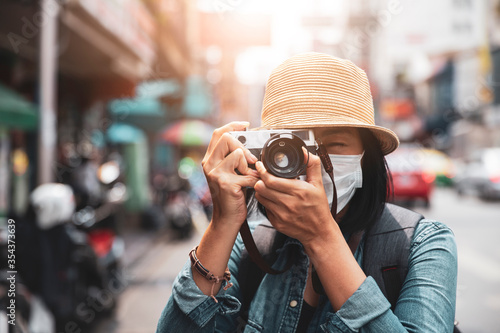 Asian women wearing surgical face mask traveler with camera travel of lifestyle portrait , outdoor summer concept © Mizkit