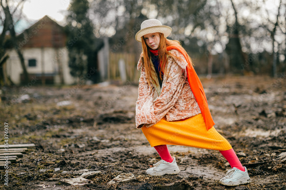 Obraz premium Funny and unusual girl in a long yellow skirt, white jacket and orange scarf rejoices
