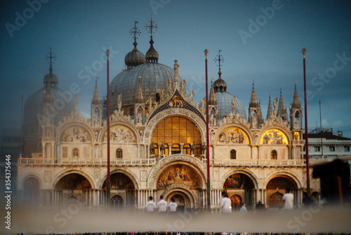 Tourists in the square in front of St. Mark's Cathedral in the evening. St. Mark's Basilica in the evening,Venice, Italy. © Anna