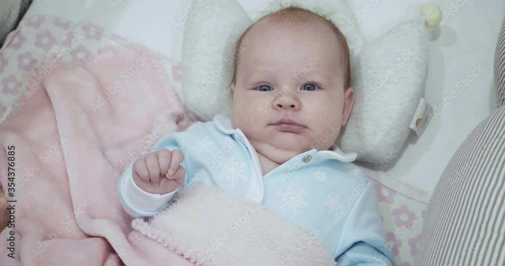Little cute newborn baby lies on her back in the crib. Little cute newborn baby lies on her back in the crib.