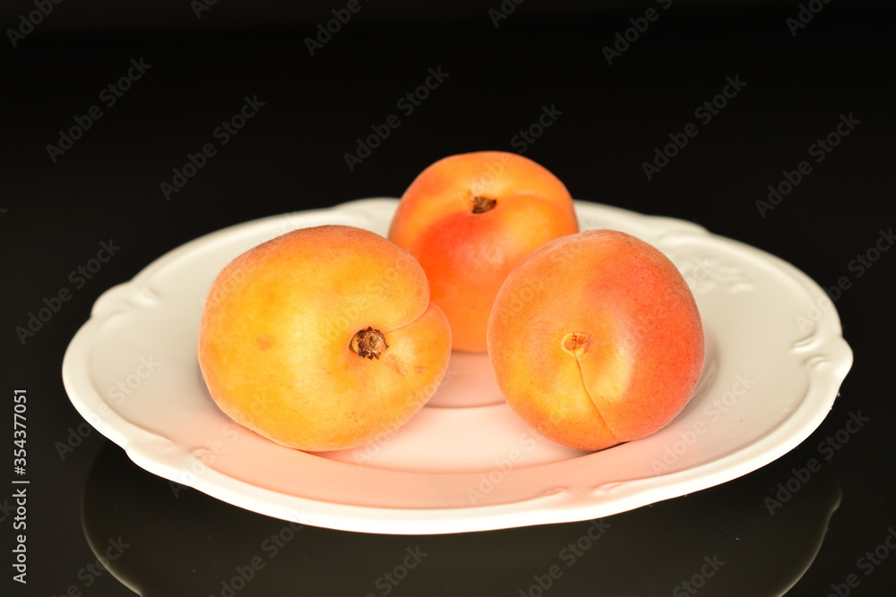 Bright yellow fresh, organic, ripe apricots, close-up, on a black background.