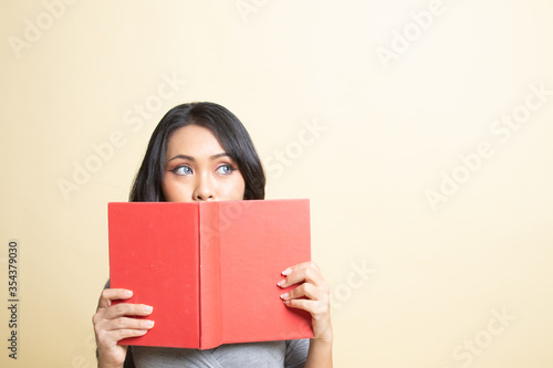 Young Asian woman with a book cover her face. © halfbottle