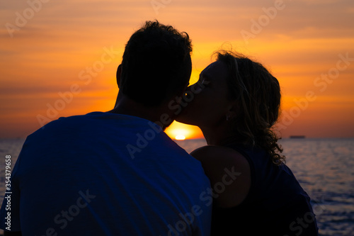 Kissing couple at sunset on the beach.