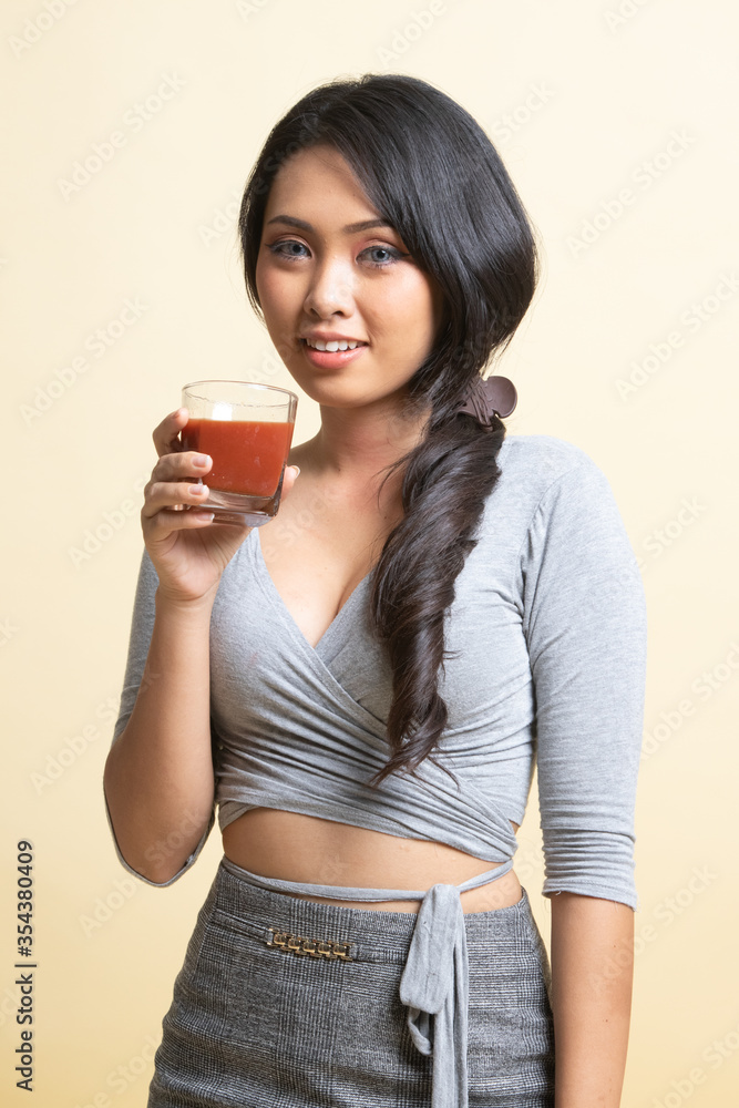 Young Asian woman drink tomato juice. Young Asian woman drink tomato juice.