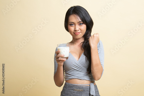 Healthy Asian woman drinking a glass of milk. © halfbottle