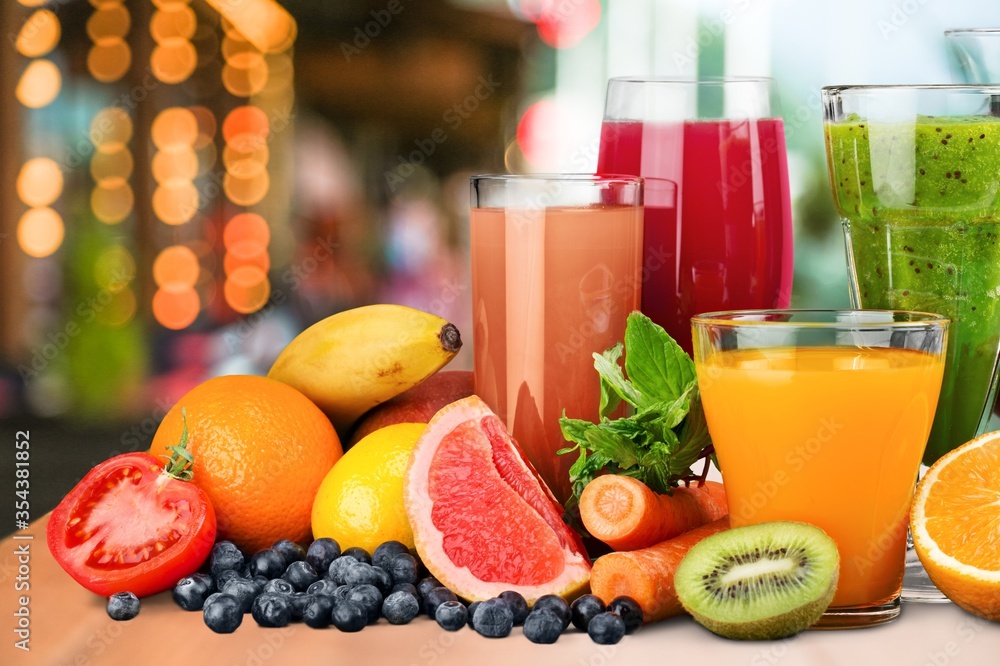 Composition of fruits and glasses of juice on the desk Composition of fruits and glasses of juice on the desk