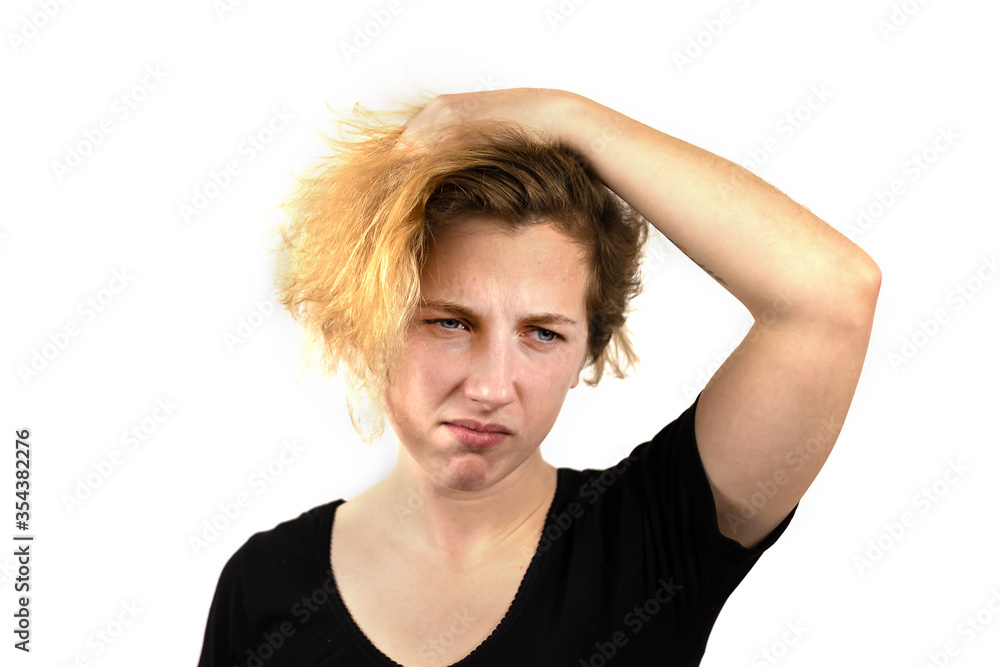 Close-up of a sad girl with disheveled hair looking slightly down. On white background. Emotion of sadness and disappointment. Bad hair day Close-up of a sad girl with disheveled hair looking slightly down. On white background. Emotion of sadness and disappointment. Bad hair day