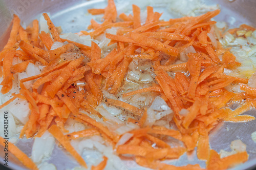 chopped onions and carrots in a frying pan.