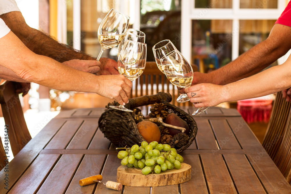 Φωτογραφία Un grupo de gente brindando con copas de vino blanco en una terraza al aire libre