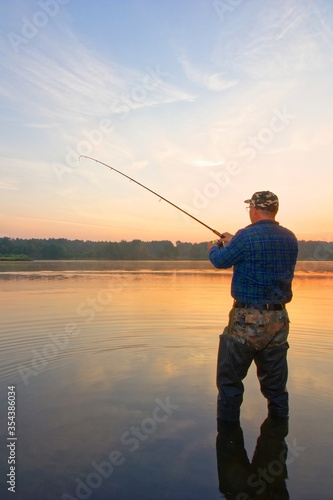 angler catching the fish during sunrise