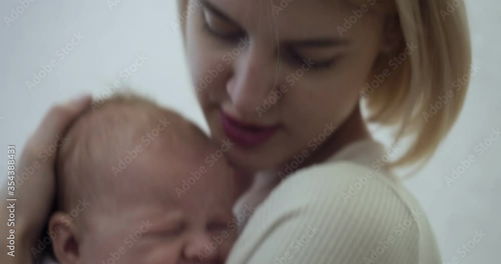 Young mother holds and cradles her crying baby on hands at home. Young mother holds and cradles her crying baby on hands at home.