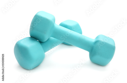Two turquoise colored rubber dumbbells lying at white table