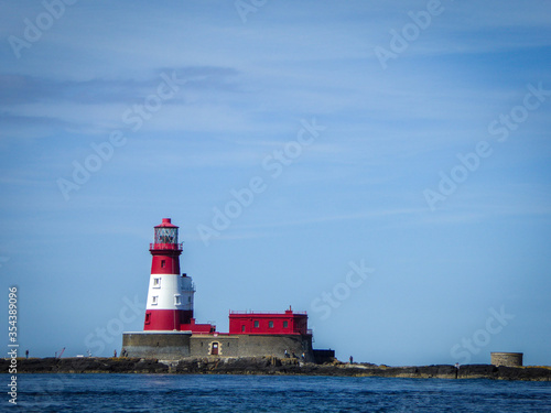 Beautiful red and white lighthouse in the Farne Islands, Northumberland, UK near the coastal town of Seahouses