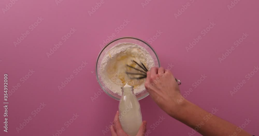Adding eggs, flour, baking powder and sugar to a glass bowl, alternating between sugar and pancakes on a white plate, stacking and pouring dulce de leche on it Adding eggs, flour, baking powder and sugar to a glass bowl, alternating between sugar and pancakes on a white plate, stacking and pouring dulce de leche on it