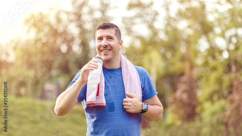 Bilde på lerret Sweaty mature jogger man drinking water after jogging