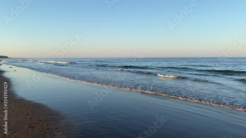 Tide arriving on the beach from the North Sea, during the sunset of a warm sunny evening.