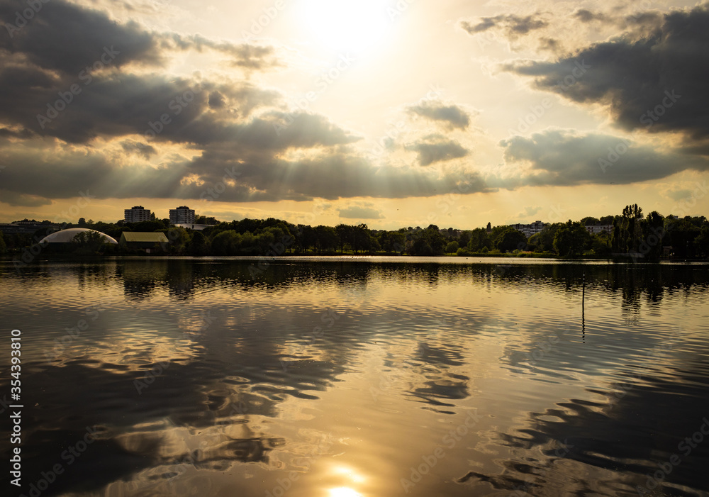 Sunset with sun rays and clouds over lake Sunset with sun rays and clouds over lake
