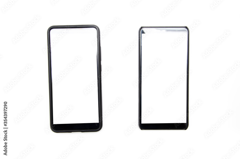 Two smartphones of black color with a white screen lie on a white background nearby, deviated from each other, top view and bottom from an angle in macro Two smartphones of black color with a white screen lie on a white background nearby, deviated from each other, top view and bottom from an angle in macro