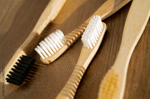 Eco-friendly bamboo toothbrushes on wooden background. Natural organic bathroom beauty product concept. Flat lay  top view  copy space.