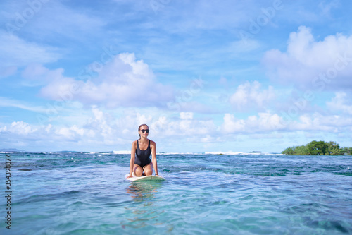 Hobby and vacation. Young sexy woman swimming over surfboard in clear blue water at  beach, Siargao Island, Philippines. © luengo_ua