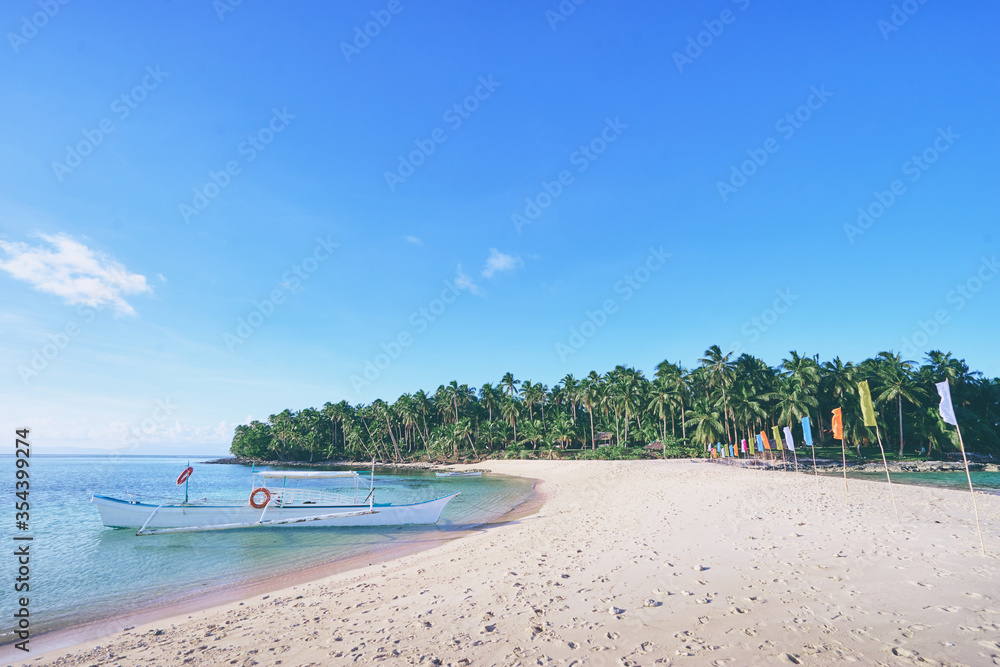 Obraz premium Beautiful landscape. White sand beach with colorful flags on it. Siargao Island, Philippines.
