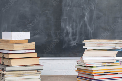 School readings arranged in a row at the front and in the background there is a school board not properly washed.