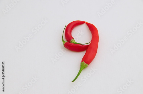Sign 9, made from the fruit of fresh chilli red pepper with a green stalk, Sofia, Bulgaria 