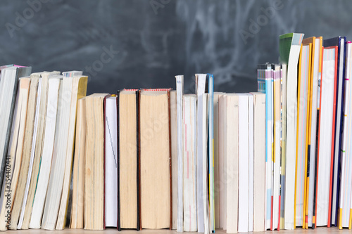 Tableau sur toile School readings arranged in a row at the front and in the background there is a school board not properly washed