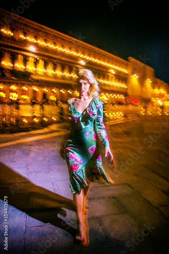 Blond girl walking in San Marco square, in Venice, Italy. Night shooting