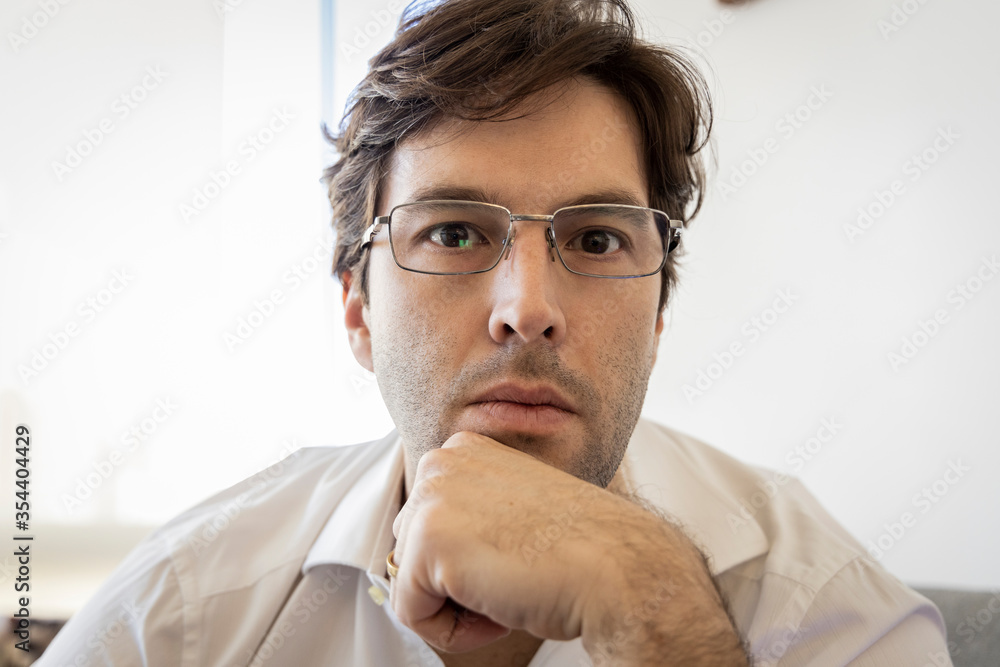 Man looking directly at the camera making a conference call. Man looking directly at the camera making a conference call.