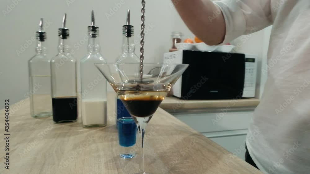The bartender pours coffee liqueur into the jigger. Slow motion The bartender pours coffee liqueur into the jigger. Slow motion