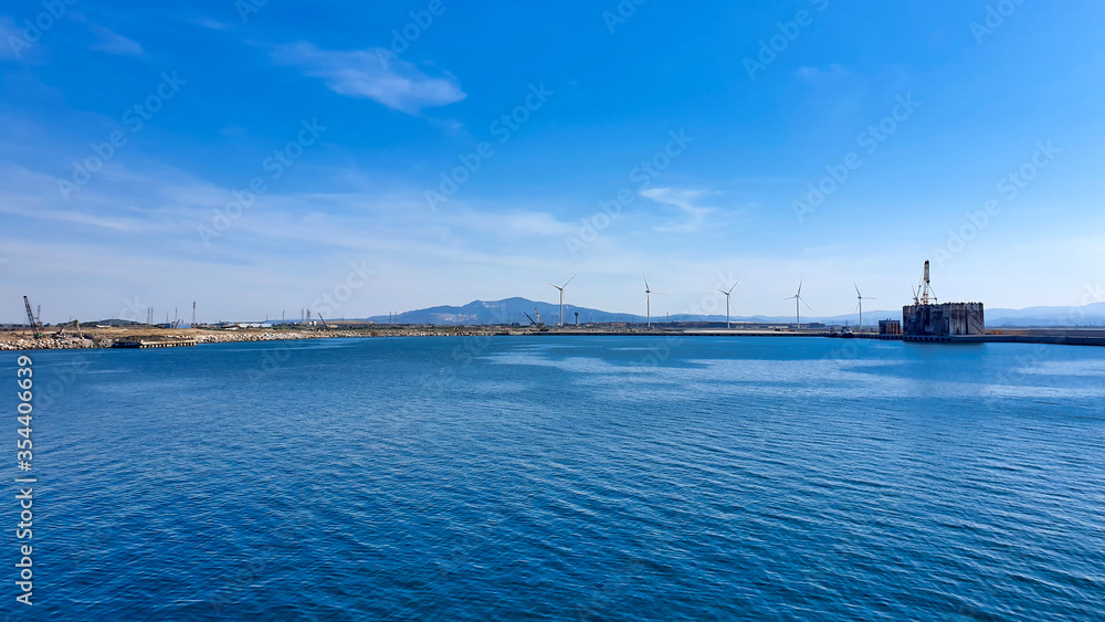 Windmills on the sea, panoramic view banner. Concept of technology and green energy