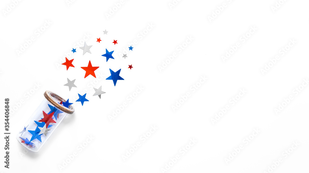 Stars confetti in color of american flag fly out the glass isolated on white backdrop. Space for text. Fourth of july. Decor for independence day of America.