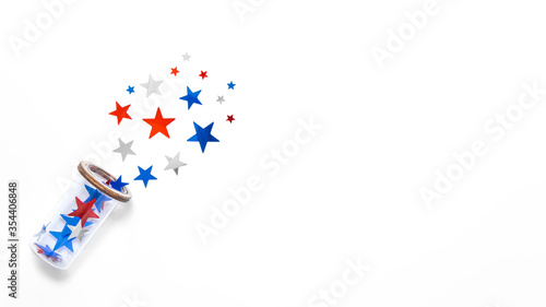 Stars confetti in color of american flag fly out the glass isolated on white backdrop. Space for text. Fourth of july. Decor for independence day of America.
