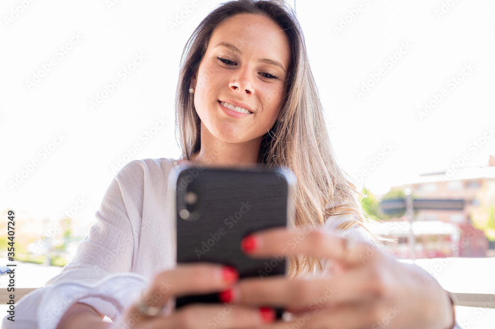 Lovely girl looks happy on her smart phone. Lovely girl looks happy on her smart phone.
