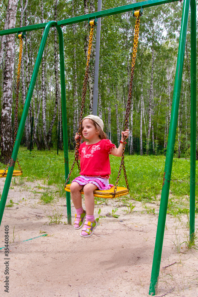 girl having fun swinging on a swing at the playground girl having fun swinging on a swing at the playground