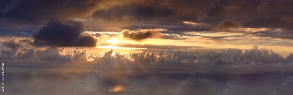 panoramic aerial view of sunset on the ocean with colored clouds