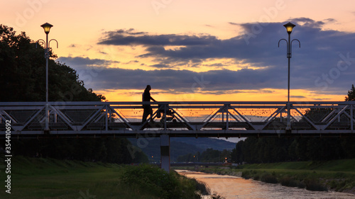 Love bridge in Pirot during colorful sunset and silhouettes of a couple with a baby 