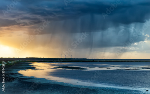 dramatic rain storm over lake at sunset © Olha Rohulya