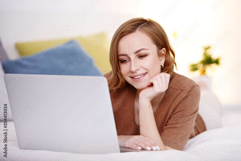 Smiling woman using laptop computer for online communication, video calling, connecting and talking, indoors at daytime. New technologies for online education and courses, self improvement classes