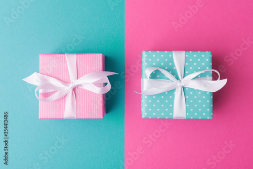 Pink and blue gift boxes with white ribbon flat lay