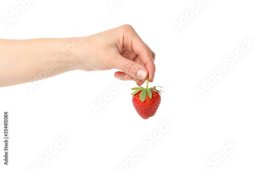 Female hand holds tasty strawberry, isolated on white background. Summer berry