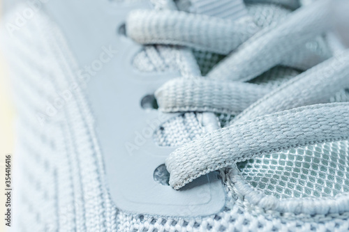 Detailed macro photo of a gray sneaker. Sports shoes for jogging. Close-up of lacing.