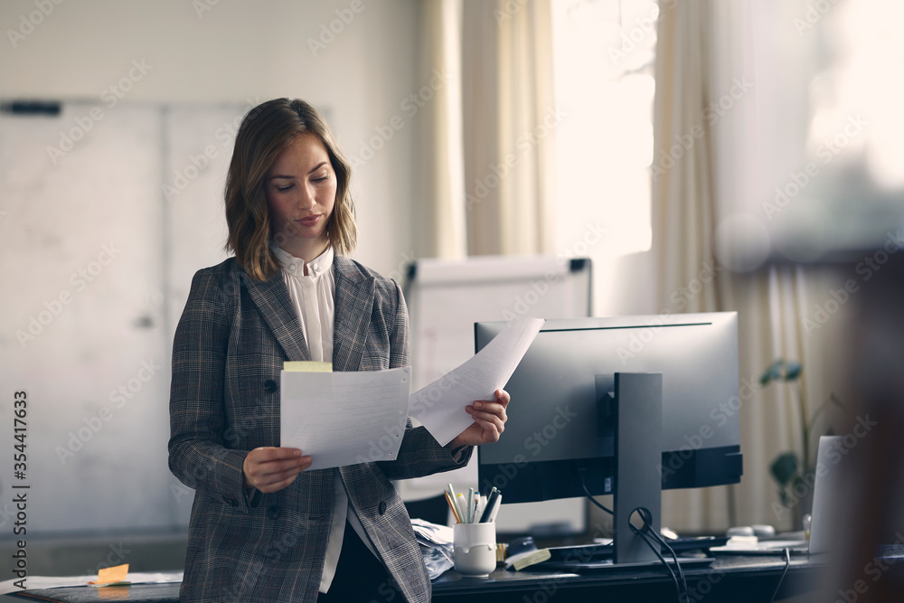 Portrait of a beautiful and professional young business woman reviewing paperwork in her modern office. Looking concentrated and serious while reading tasks. Ready to work. Portrait of a beautiful and professional young business woman reviewing paperwork in her modern office. Looking concentrated and serious while reading tasks. Ready to work.