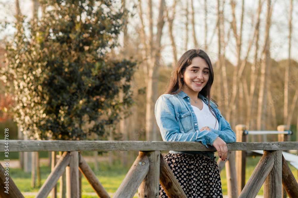 caucasian girl standing on a wooden bridge looking at the camera. great copy space caucasian girl standing on a wooden bridge looking at the camera. great copy space
