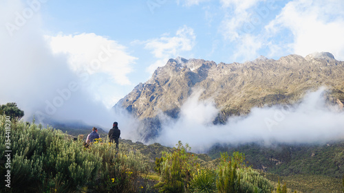 mountain landscape in the morning, two trekkers watching sunrise in Rwenzori Mountains in Uganda, Central Eastern Africa photo
