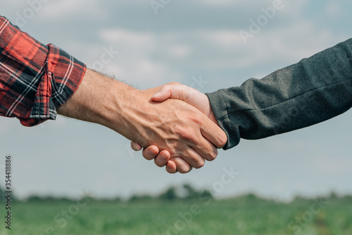 Mortgage loan officer and farmer shaking hands upon reaching an agreement photo